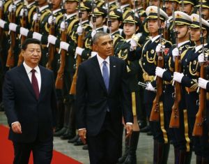 China's President Xi Jinping (L) walks with U.S. President Barack Obama (C) as they inspect the honour guards during a welcoming ceremony at the Great Hall of the People in Beijing, November 12, 2014. REUTERS/Petar Kujundzic